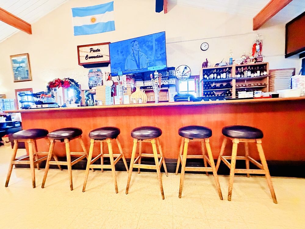 The bar at Pasta Connection with the Argentine flag overhead and the house wine selection